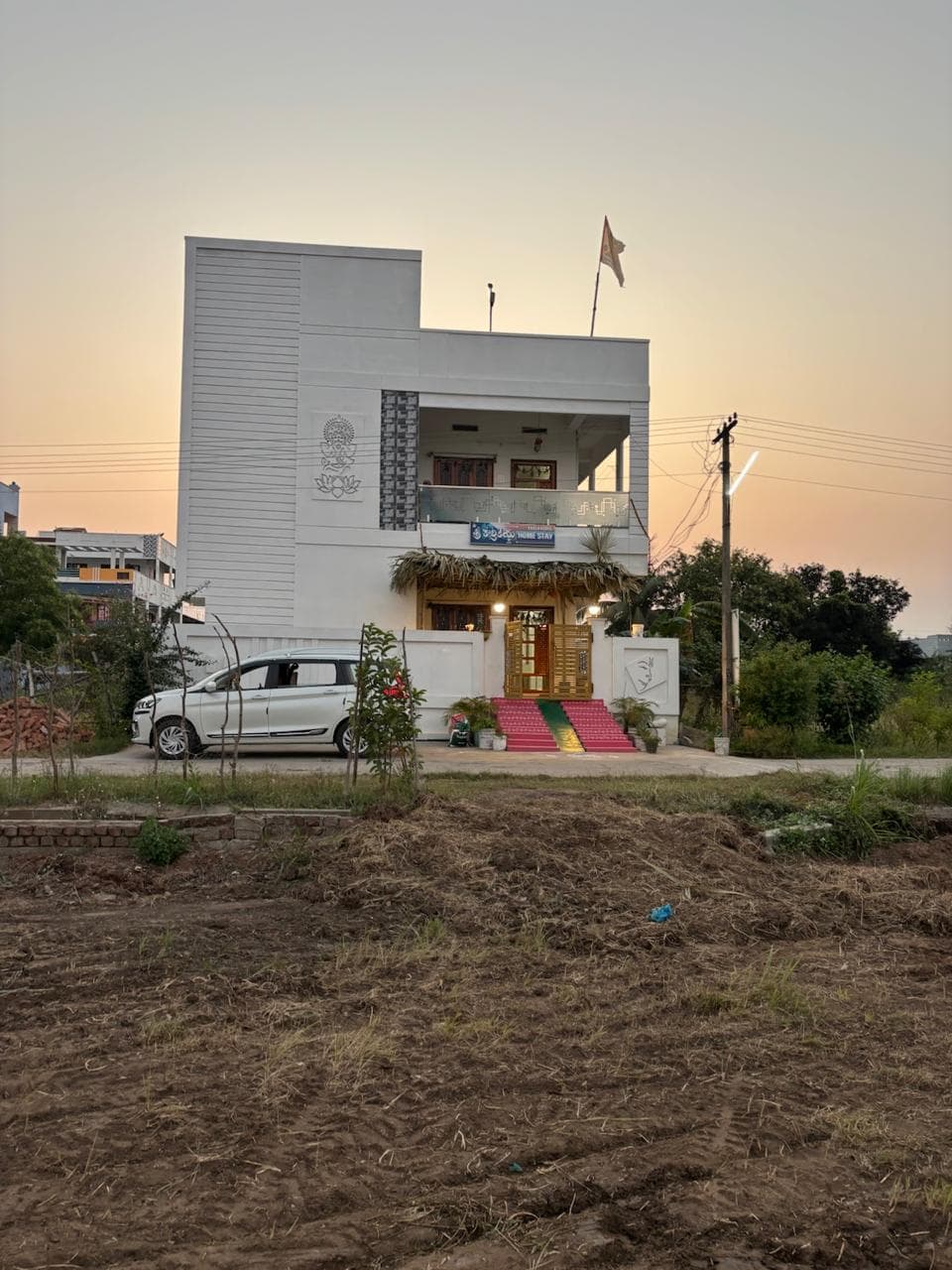 Homestay exterior at dusk with HOME STAY signboard